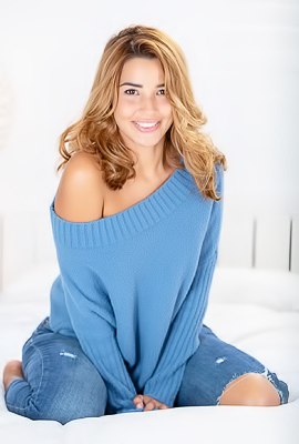 Agatha Vega takes off her blue sweater and jeans on the bed