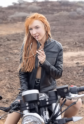 Lilly Mays Rides A Motorcycle In The Desert Wearing A Leather Jacket And Miniskirt